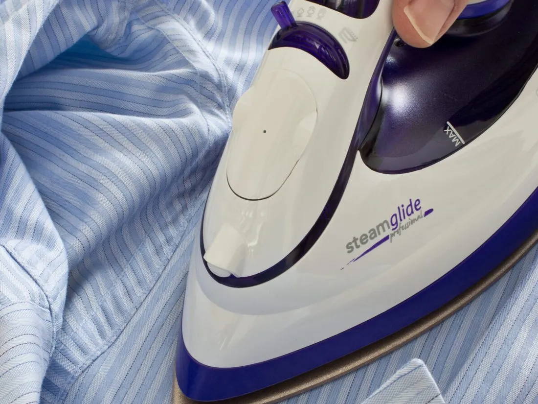 Close-up of a shirt being hand-pressed
